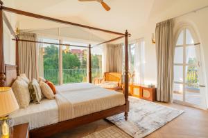 a bedroom with a canopy bed and a balcony at Casa Mandala by ELIVAAS in Candolim