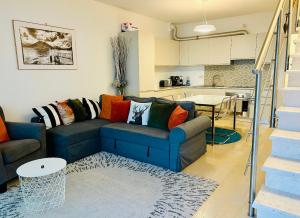 a living room with a blue couch and a kitchen at Argegno Pool apartment by Italian Apartments in Argegno