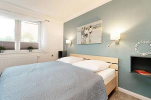 a bedroom with a bed with a blue wall at Instenweg 14 Sternhus in Rettin