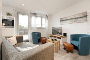 a living room with a couch and chairs and a tv at Instenweg 14 Sternhus in Rettin