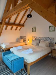 two beds in a room with wooden ceilings at GO4SURF beach Lofts in Peniche