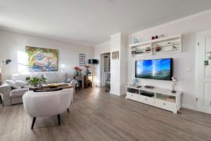 a living room with a couch and a flat screen tv at Wohnung 9 in Westerland