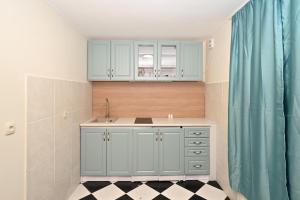 a kitchen with blue cabinets and a sink at Two bedroom Vintage apartment in Kotor +55 photos