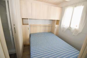 a small bed in a small room with a window at VILLAGGIO TURISTICO LA FOCE SpA in Toscolano Maderno