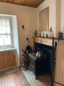 a living room with a fireplace and a mirror at Maisonnette ardéchoise au centre du village in Nozières