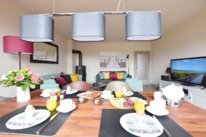 a living room with a table and a living room at Ferienhaus Barke 17 in Tinnum