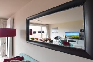 a large mirror on the wall of a living room at Ferienhaus Barke 17 in Tinnum