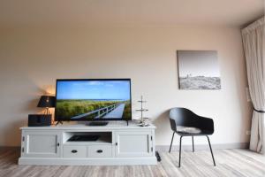 a living room with a television on a white entertainment center at Ferienhaus Barke 17 in Tinnum