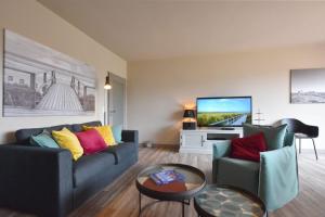 a living room with two couches and a flat screen tv at Ferienhaus Barke 17 in Tinnum +24 photos