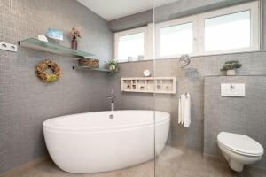 a bathroom with a white tub and a toilet at Instenweg 14 Fischhus in Rettin
