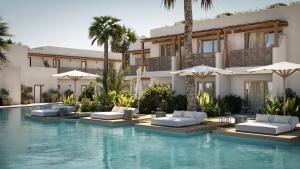 a resort with a swimming pool with chairs and umbrellas at Phāea Cretan Malia, a Member of Design Hotels in Malia