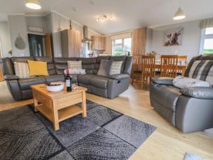 a living room with a leather couch and a table at Holly Lodge in Holywell