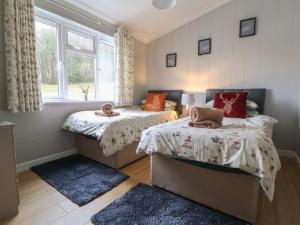 a bedroom with two beds and a window at Holly Lodge in Holywell