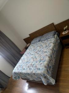 a bedroom with a bed with a blue comforter at Casa aconchego in Socorro