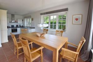 a kitchen and dining room with a wooden table and chairs at Ferienhaus Helen in Morsum +26 photos