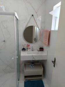 a bathroom with a sink and a mirror at Casa aconchego in Socorro +4 photos