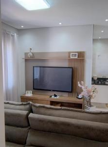 a living room with a large flat screen tv at Casa aconchego in Socorro