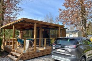 a house with a car parked in front of it at Camping le Relais du Léman in Messery