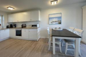 a kitchen and dining room with a table and chairs at Ferienhaus Alte Dorfstraße 20 in Tinnum