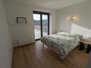 a bedroom with a bed and a large window at Gîte du Vieux Cuvage in Vaux-en-Beaujolais +8 photos