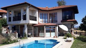 a house with a swimming pool in front of it at Villa Jasmin in Aheloy