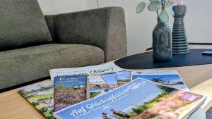 ein Tisch mit zwei Büchern und einer Vase darauf in der Unterkunft Ferienhaus Calluna Stilvolle Doppelhaushälfte in der Lüneburger Heide, Hunde willkommen in Winsen