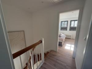ein Flur mit einer Treppe und ein Zimmer mit einem Stuhl in der Unterkunft Ferienhaus Calluna Stilvolle Doppelhaushälfte in der Lüneburger Heide, Hunde willkommen in Winsen + 7 Fotos