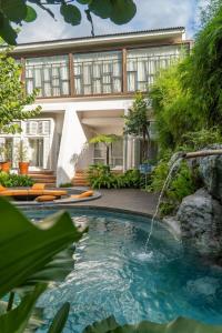 a house with a swimming pool with a waterfall at YATS Colony in Yogyakarta