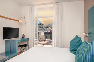 a bedroom with a bed and a desk and a window at Hotel Piazza Bellini & Apartments in Naples +104 photos