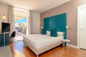 a bedroom with a large bed with a blue headboard at Hotel Piazza Bellini & Apartments in Naples