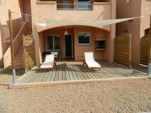 two chairs on a wooden deck in front of a house at Residence Conca Blue in Conca +14 photos
