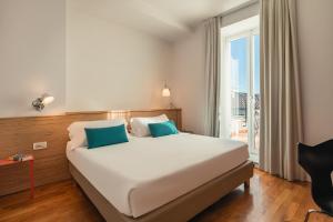 a bedroom with a bed and a large window at Hotel Piazza Bellini & Apartments in Naples