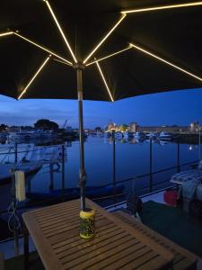 a table with an umbrella on top of a marina at Peniche Saul Nomad in Aigues-Mortes