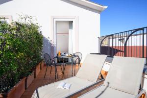a balcony with two chairs and a table at Hotel Piazza Bellini & Apartments in Naples
