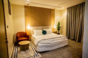 a hotel room with a bed and a chair at EXQUISITE Home 2 Abuja in Abuja
