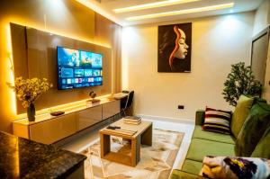 a living room with a couch and a tv at EXQUISITE Home 2 Abuja in Abuja