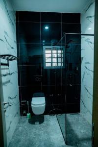 a bathroom with a toilet and a glass shower at EXQUISITE Home 2 Abuja in Abuja +3 photos