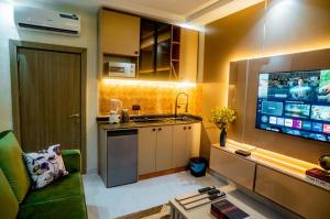 a living room with a kitchen and a tv in a room at EXQUISITE Home 2 Abuja in Abuja