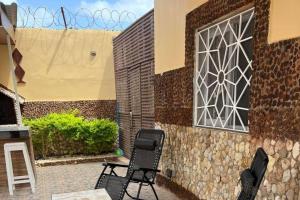 two chairs sitting on a patio next to a building at Sendou Cabano Villa Sleeps 6 with Parking in Siendou