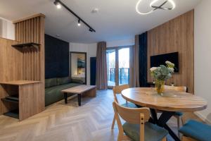 a living room with a table and a couch at Apartamenty Beski in Szczyrk +10 photos