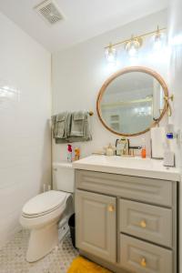 a bathroom with a sink and a toilet and a mirror at Flint and Kingscrest, LLC - Private Rooms in Shared Home in Orlando