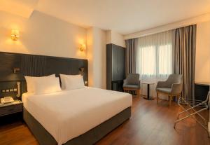 a hotel room with a bed and a table and chairs at Best Western Izmir Hotel in İzmir +60 photos