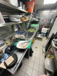 a kitchen with a counter with plates and pans at Hotel Casa Square in Indore