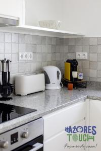 a kitchen with a counter top with a toaster at Casa Menino do Mar in Porto Judeu