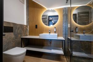 a bathroom with two sinks and a toilet at Apartamenty Beski in Szczyrk