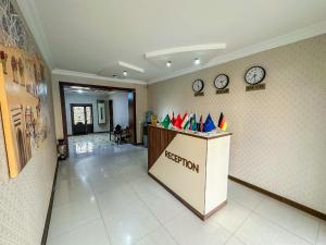 an office with a reception desk and clocks on the wall at Gold Camel Registan in Samarkand