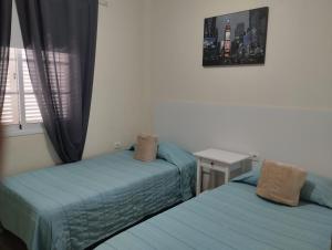 a bedroom with two beds and a window at apartamentos la villa in San Sebastián de la Gomera