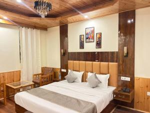 a bedroom with a bed and a chandelier at Liora Stays in Palchān