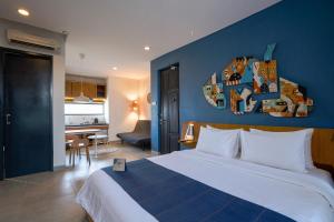 a bedroom with a large bed and a blue wall at YATS Colony in Yogyakarta +55 photos