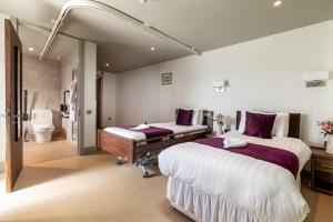 a bedroom with two beds and a bathroom at Maison des Landes - Accessible Hotel in St. Ouen's